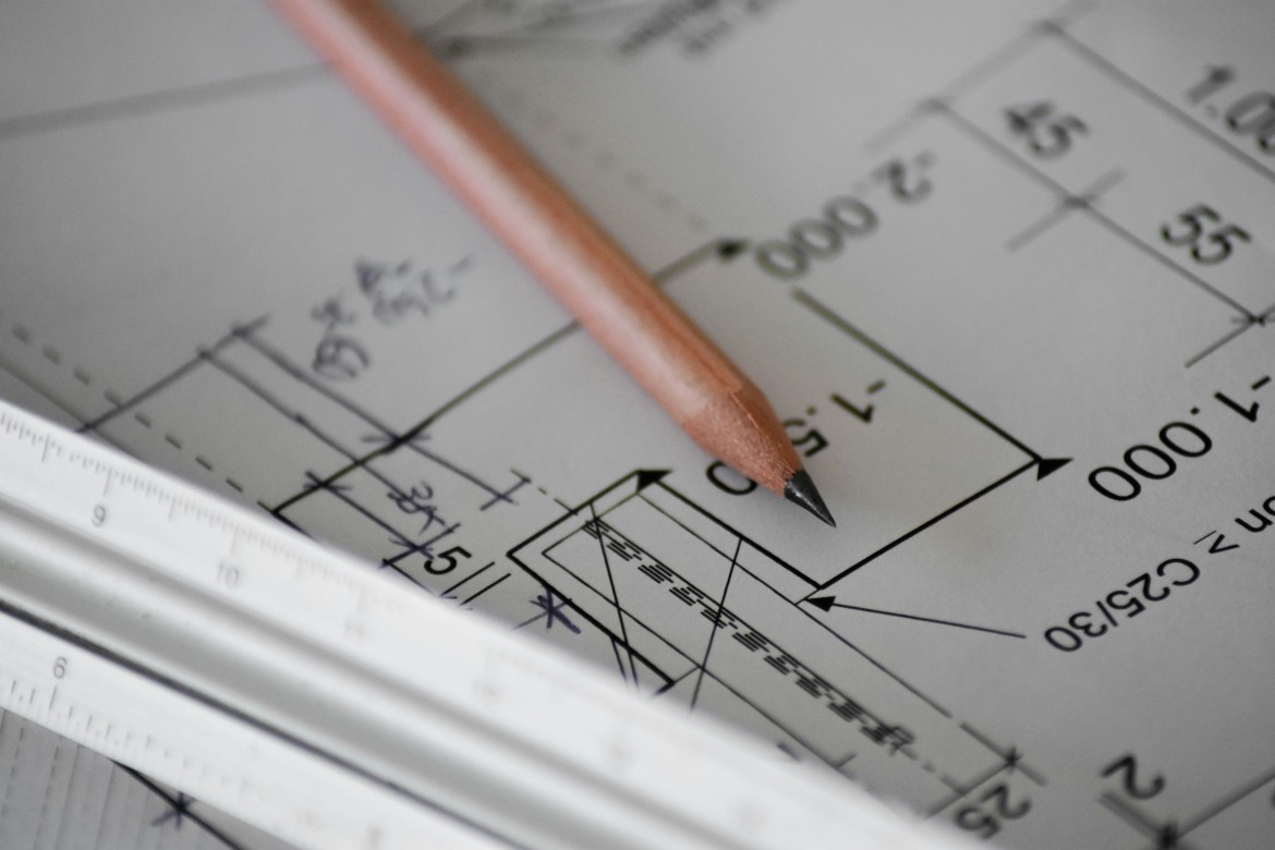 Close-up of a technical drawing with a pencil and scale ruler resting on the paper
