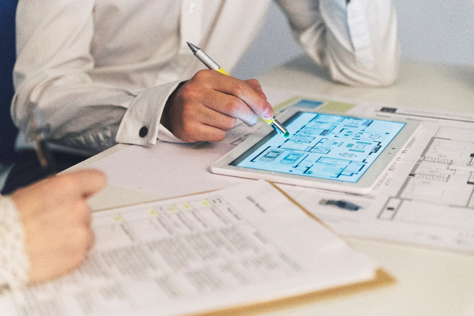 Engineer reviewing digital floor plans on a tablet